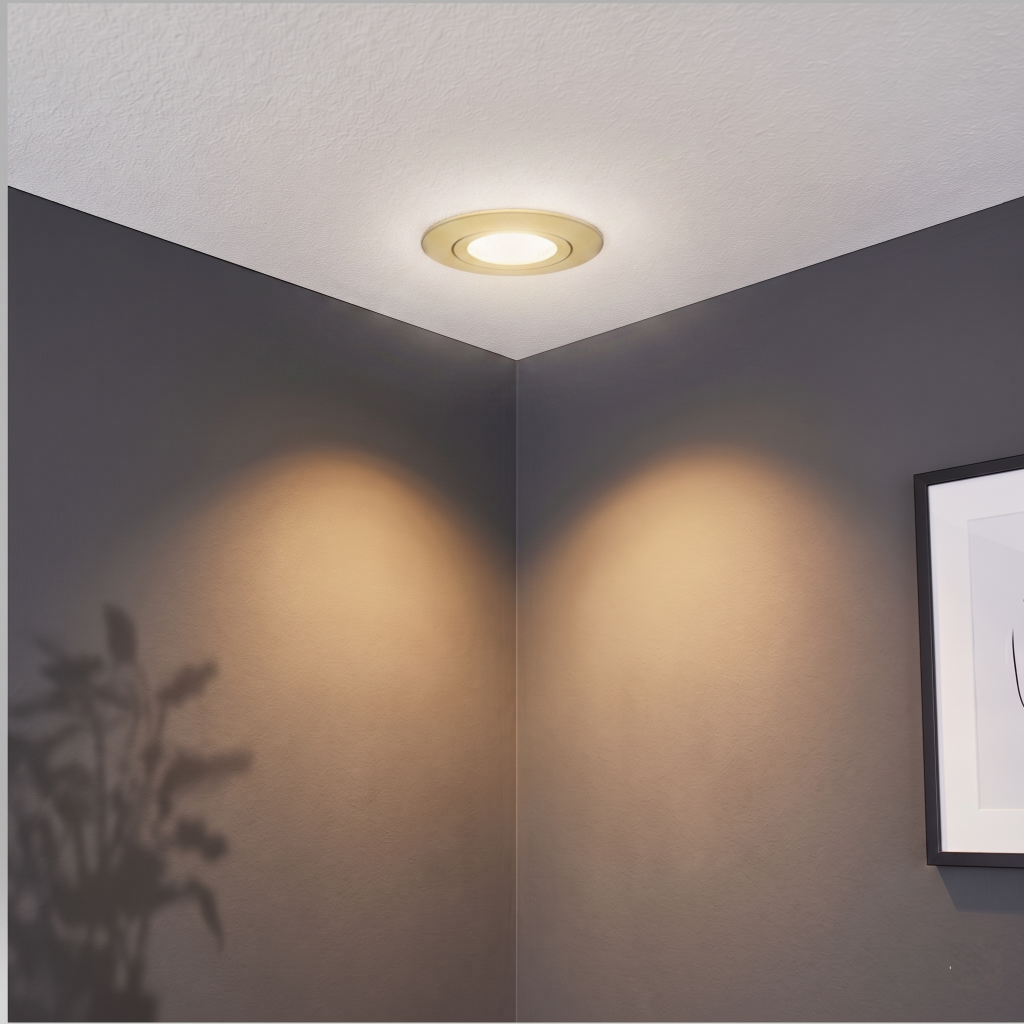Gouden Miran inbouwspot gemonteerd in een wit gestuct plafond, sfeervol uitgelicht tegen een strakke antraciete wand.