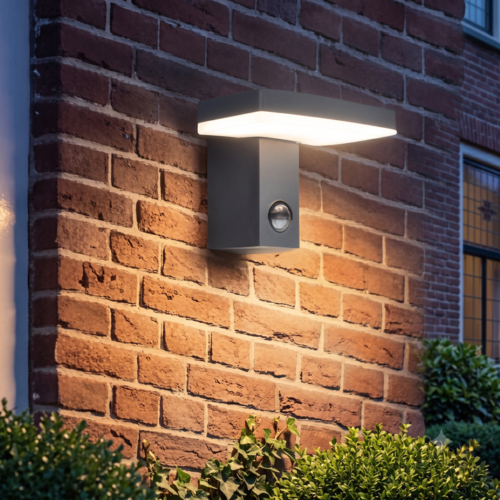 Wandlamp Roberto met een strak en rechthoekig design voorzien van dag nacht en beweings sensor gemonteerd tegen een gemetselde muur