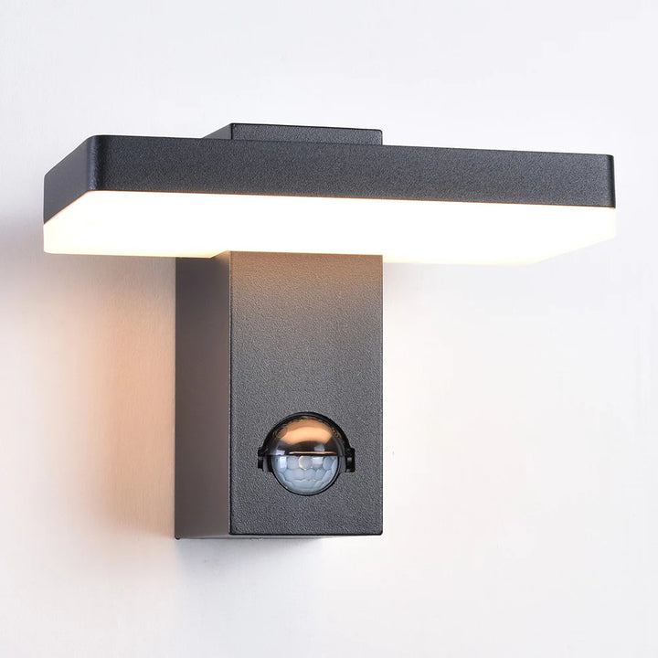 schuin van voren afbeelding van de brandendende wandlamp roberto met geactiveerde sensoren