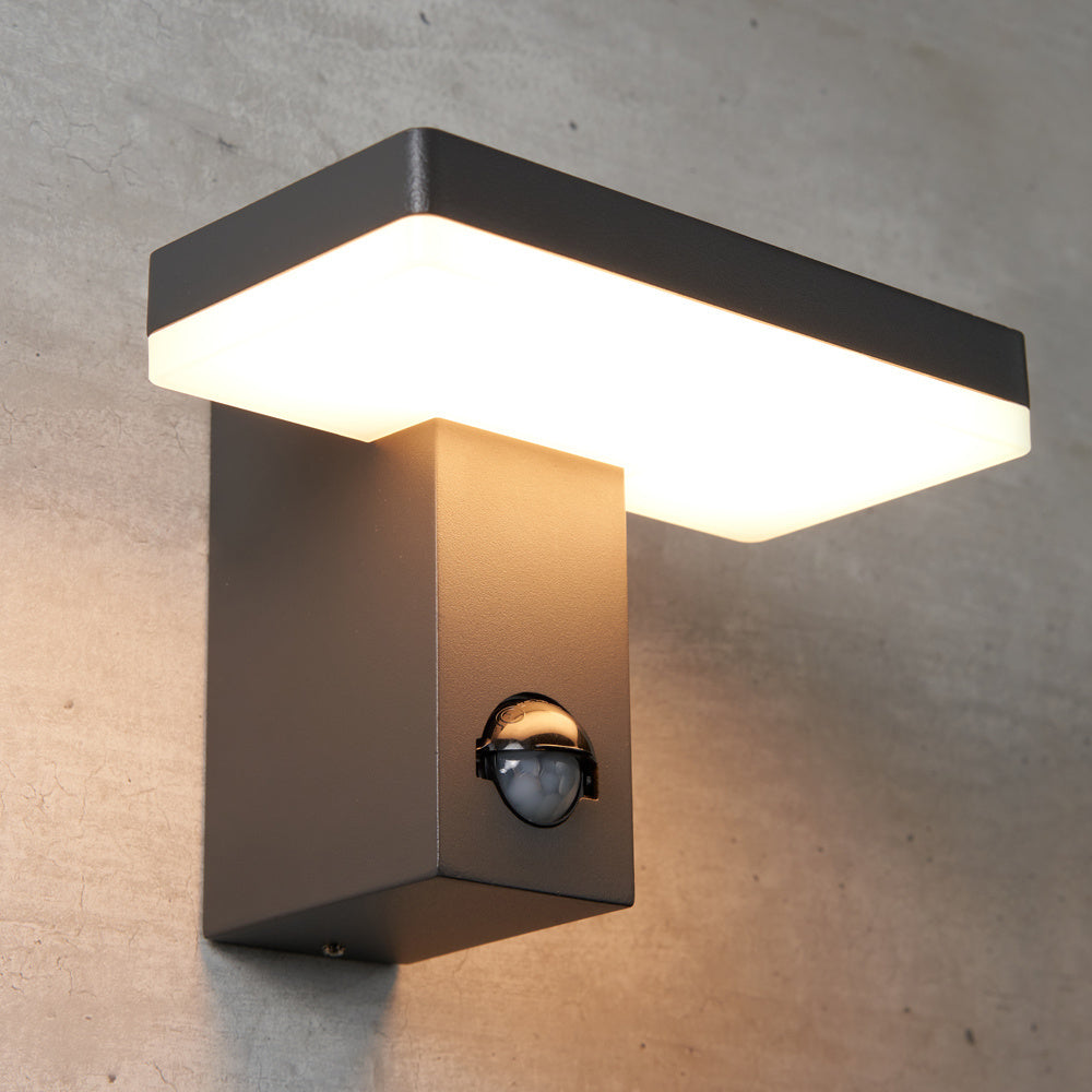 Matzwarte wandlamp met 2 senoren en tijdfunctie gemonteerd tegen een betonnen wand