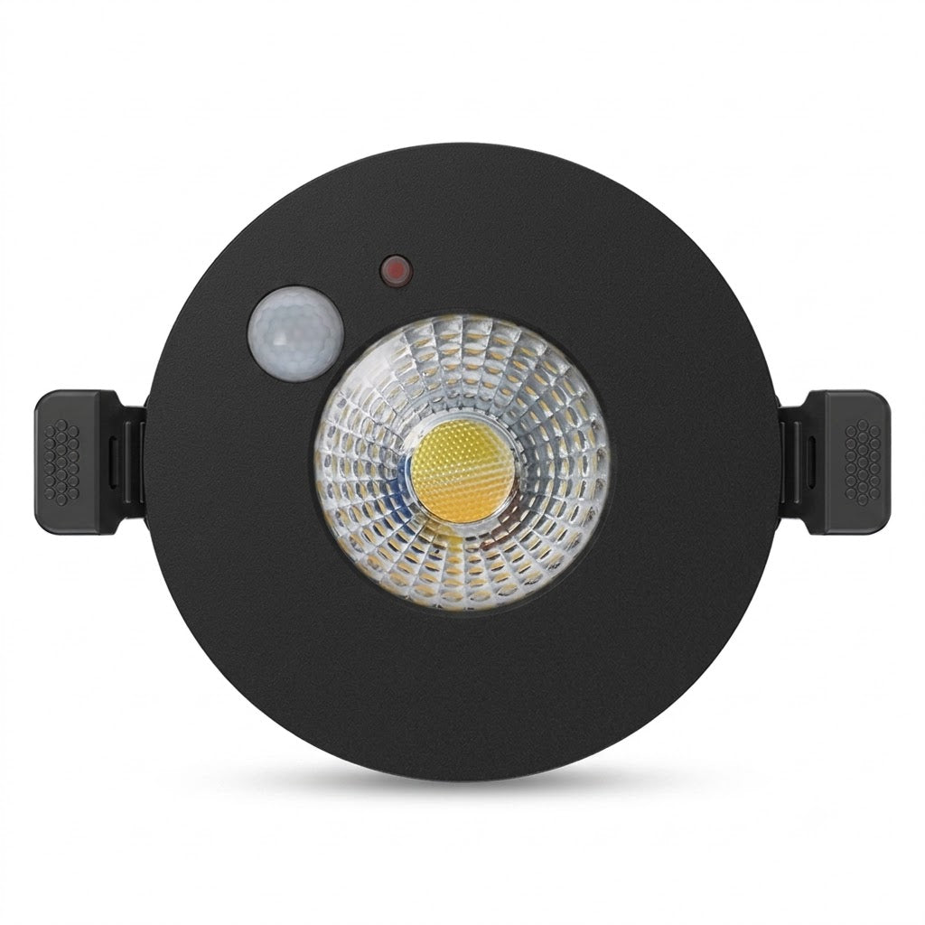 Matzwarte, ronde LED inbouwspot met ingebouwde PIR-bewegingssensor en daglichtsensor. De spot heeft een heldere reflectorlens met een zichtbare gele COB LED en is voorzien van zwarte montagebeugels.