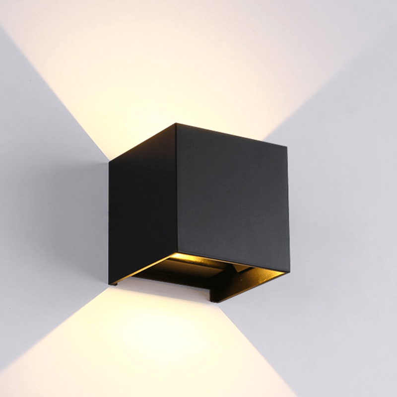 Zwarte LED kubusarmatuur Thebe met 2x3W dubbele lichtbundel, dimbaar, IP54-geclassificeerd, op een egale witte ondergrond met lichtspreidings effect op een witte achtergrond